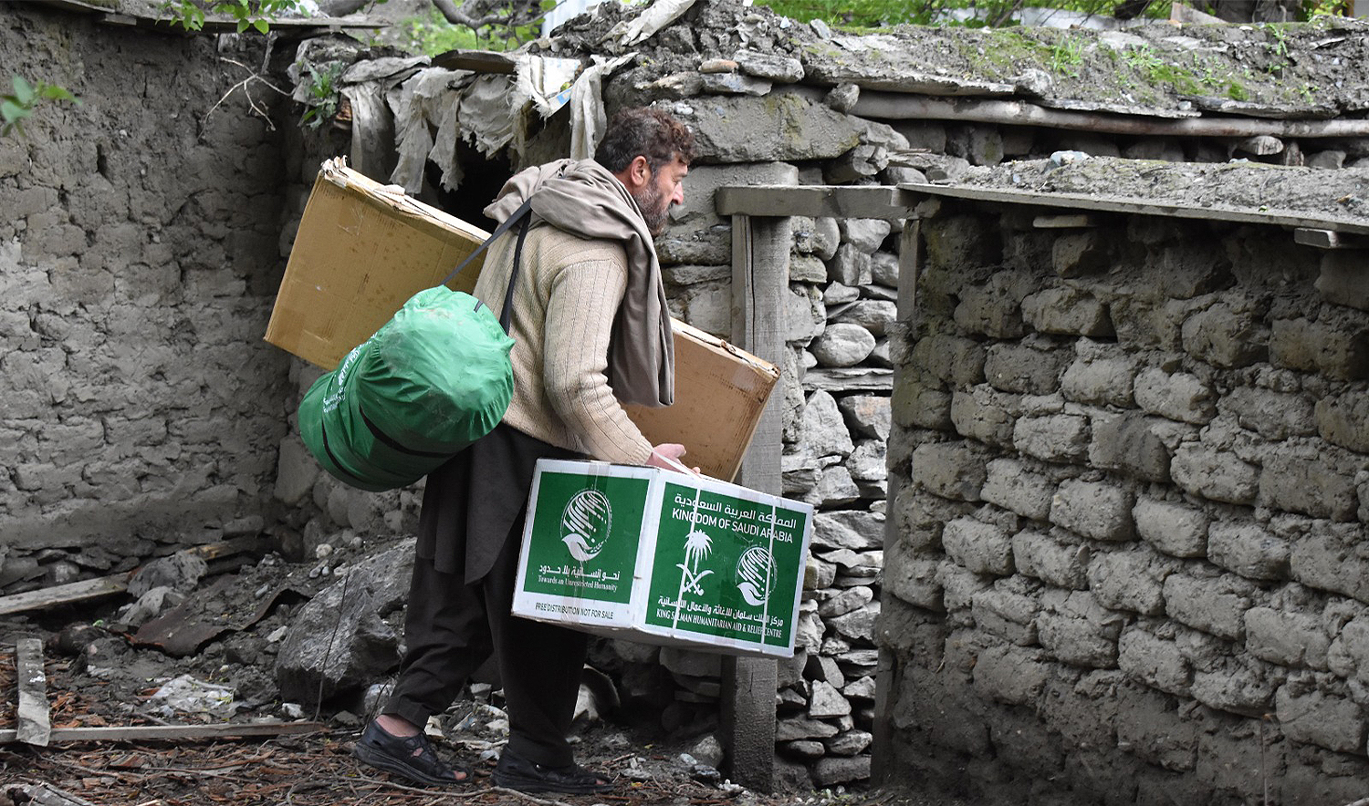The picture shared by KSrelief on November 5, 2024 shows a Pakistani man carrying winter supplies provided by KSrelief. (KSrelief)