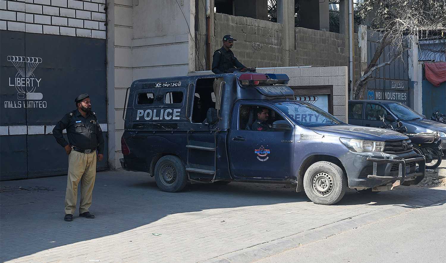 Pakistan policemen stand guard outside a factory where two Chinese nationals were allegedly shot, in Karachi on November 5, 2024. (AFP)
