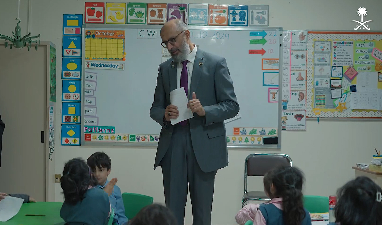 In this screengrab, taken from a handout video released by Saudi Arabia’s Ministry of Media on November 8, 2024, Pakistani academic Muhammad Tanveer greets his students at the Pakistan International School Riyadh in Riyadh. (Photo courtesy: Saudi Ministry of Media)