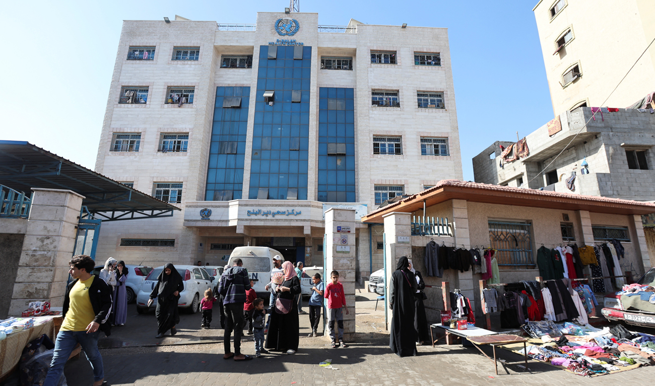 Palestinians walk outside a health center run by United Nations Relief and Works Agency (UNRWA), amid the Israel-Hamas conflict, in Deir Al-Balah, in the central Gaza Strip on October 29, 2024. (REUTERS/File)