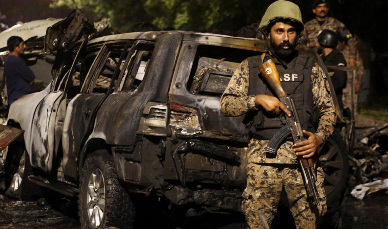 A member of the Airport Security Force ASF stands guard near the wreckage of vehicles after an explosion near Jinnah International Airport in Karachi, Pakistan on October 6, 2024. (REUTERS/File)
