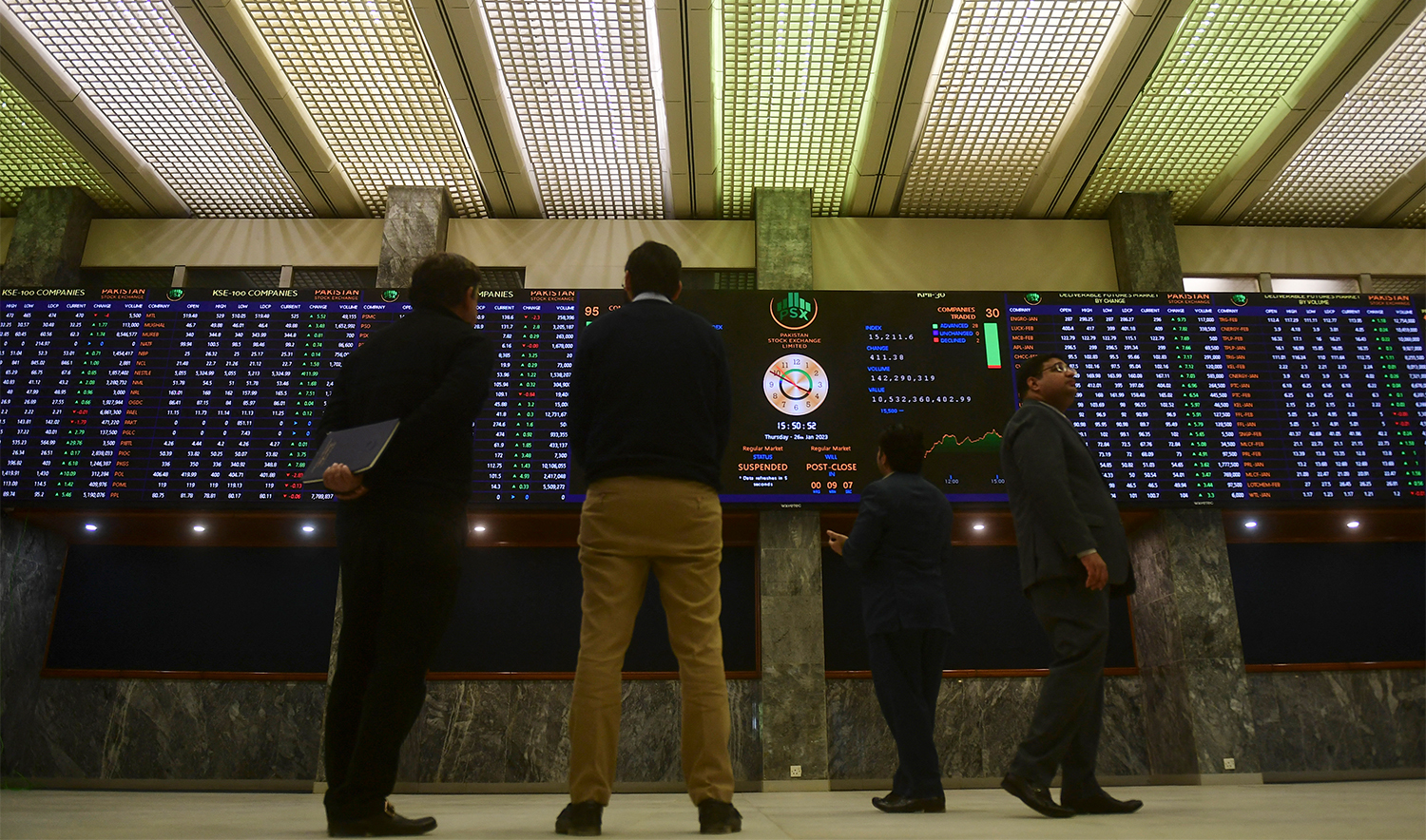Brokers monitor an index board showing latest share prices at the Pakistan Stock Exchange in Karachi on January 26, 2023. (AFP/File)