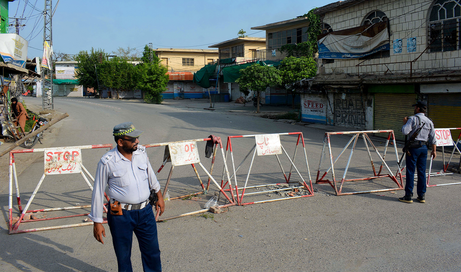 Policemen stand guard along a barricaded street near an army cantonment in Bannu, Pakistan, on July 16, 2024. (AFP/File)
