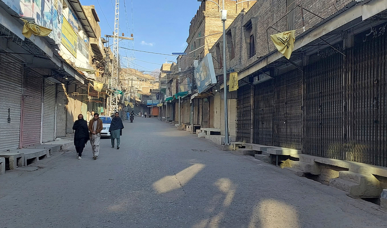 Local residents walk in a market, which closed due to strike called by traders as a protest against a gunmen firing incident, in Parachinar, main town of district Kurram, Pakistan, on November 22, 2024. (AP)