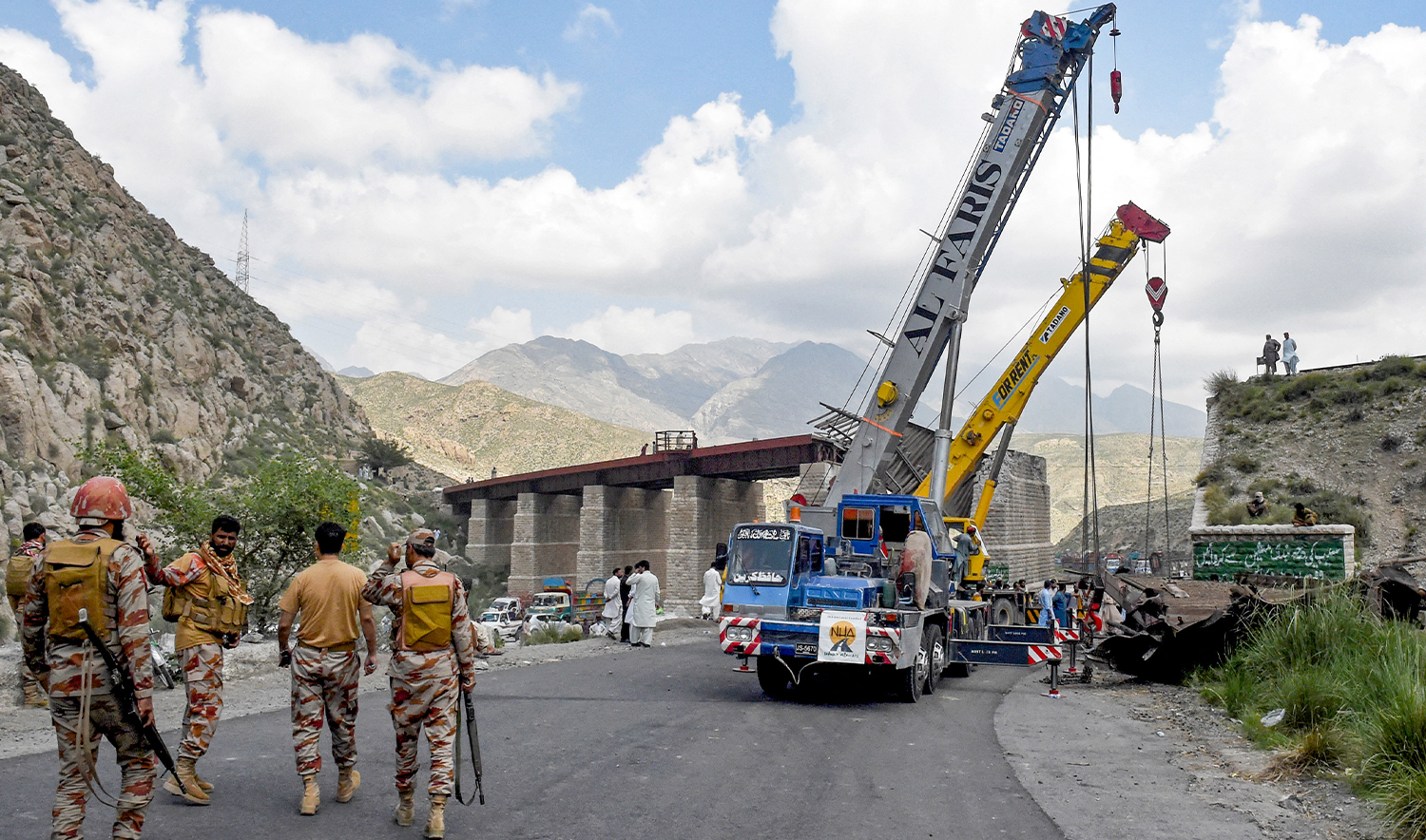 Pakistan's paramilitary rangers walk past cranes clearing the wreckage of a collapsed railway bridge a day after a blast by separatist militants at Kolpur in Bolan district, Balochistan province on August 27, 2024. (AFP/File)