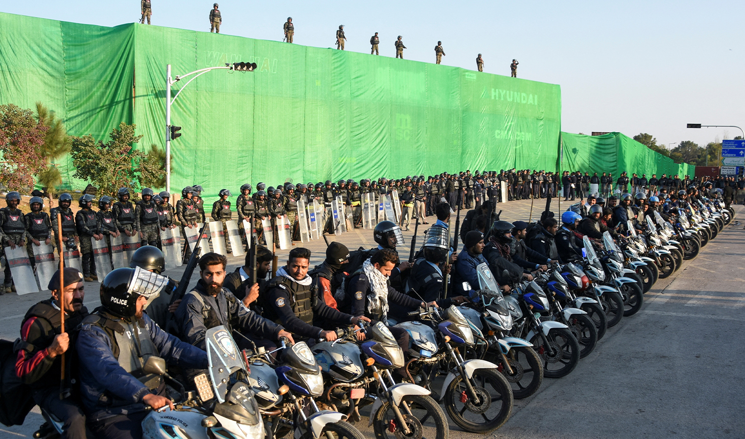 Police officers sit on motorbikes with shipping containers in the background, used to prevent an anti-government rally by supporters of the former Pakistani Prime Minister Imran Khan's party Pakistan Tehreek-e-Insaf (PTI), in Islamabad, Pakistan on November 24, 2024. (REUTERS)
