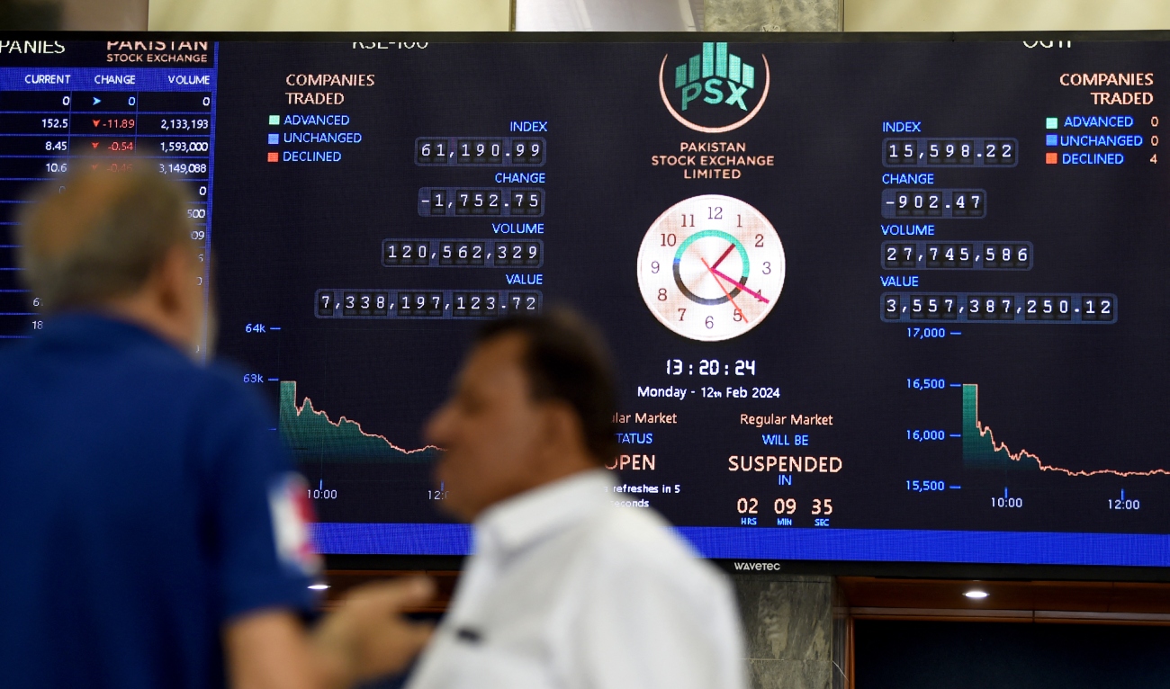 Stock brokers monitor share prices displayed on a digital screen during a trading session at the Pakistan Stock Exchange (PSX) in Karachi on February 12, 2024. (AFP/File)