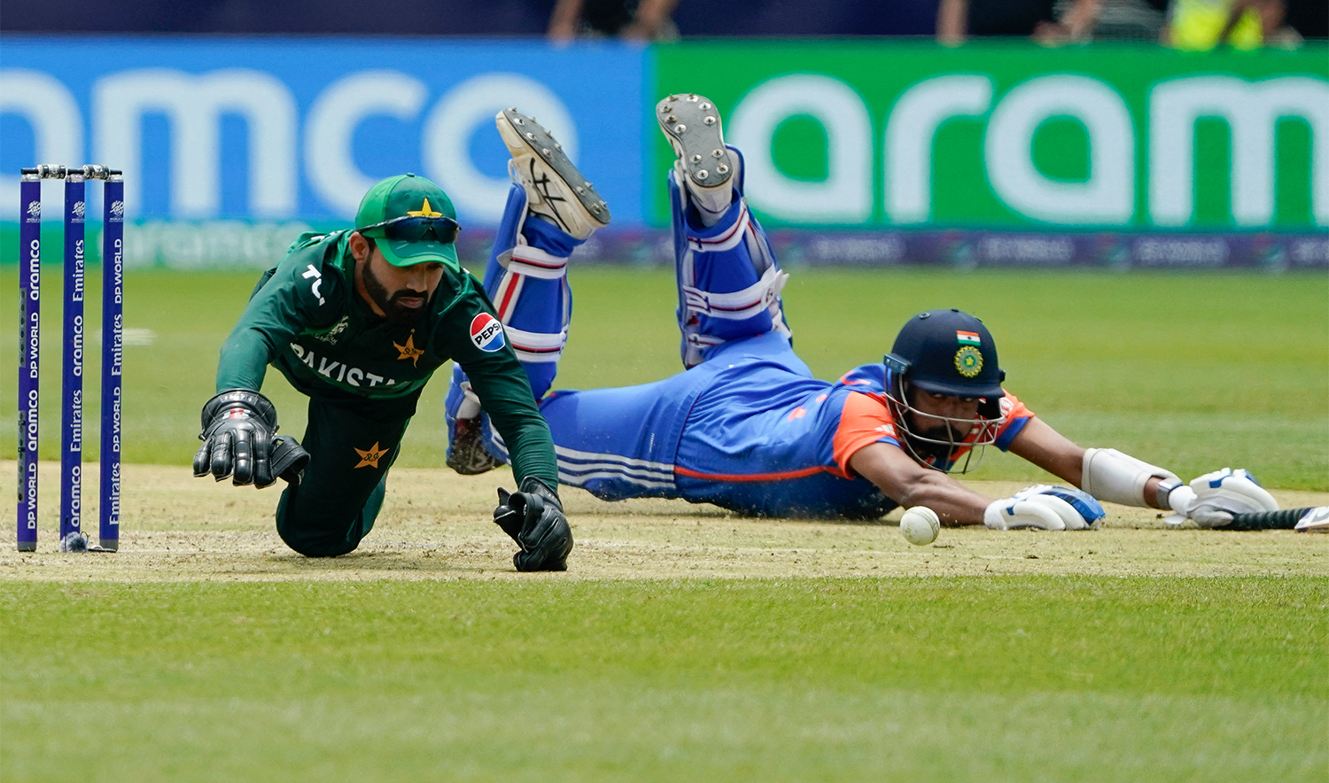 Pakistan's wicket keeper Mohammad Rizwan (L) dives for the ball during the ICC men's Twenty20 World Cup 2024 group A cricket match between India and Pakistan at Nassau County International Cricket Stadium in East Meadow, New York on June 9, 2024. (AFP/File)