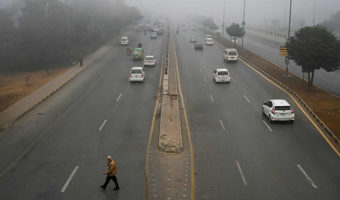 Commuters make their way along a road amid dense smog in Islamabad on January 22, 2024. (AFP/File)