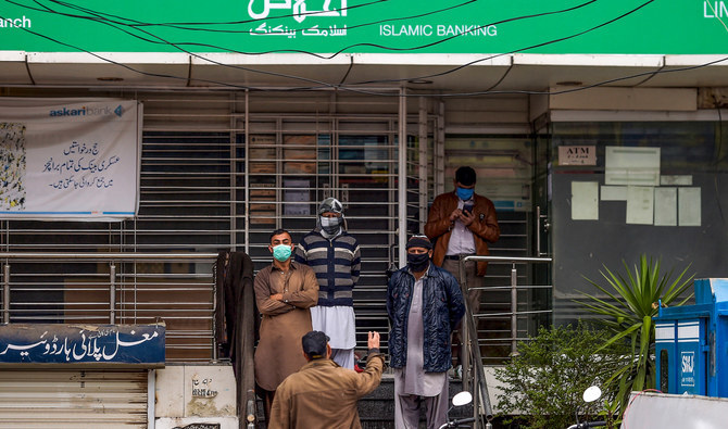 People wait for the bank opening in Islamabad, Pakistan, on March 24, 2020. (AFP/File)