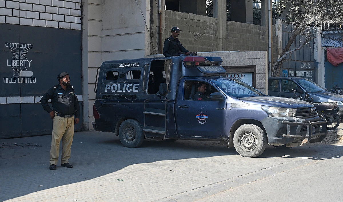 Pakistan policemen stand guard outside a factory where two Chinese nationals were allegedly shot, in Karachi on November 5, 2024. (AFP)