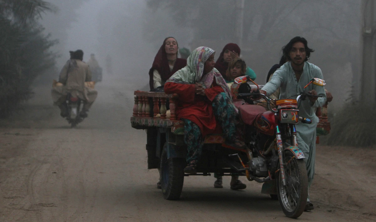 A family moves on a trishaw along a road on a smoggy morning on the outskirts of Multan on November 11, 2024. (REUTERS)
