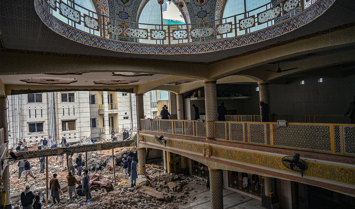 Plain-clothed policemen gather over the rubble of a damaged mosque following January's 30 suicide blast inside the police headquarters in Peshawar on February 1, 2023. (AFP/File)
