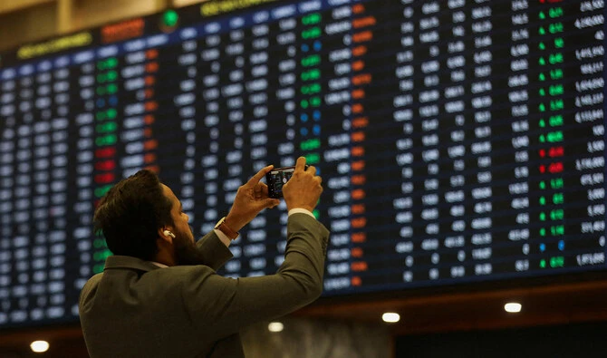 A man uses mobile phone to take a photo of the electronic board displaying share prices during a trading session at the Pakistan Stock Exchange, in Karachi, Pakistan on November 28, 2023. (REUTERS/File)