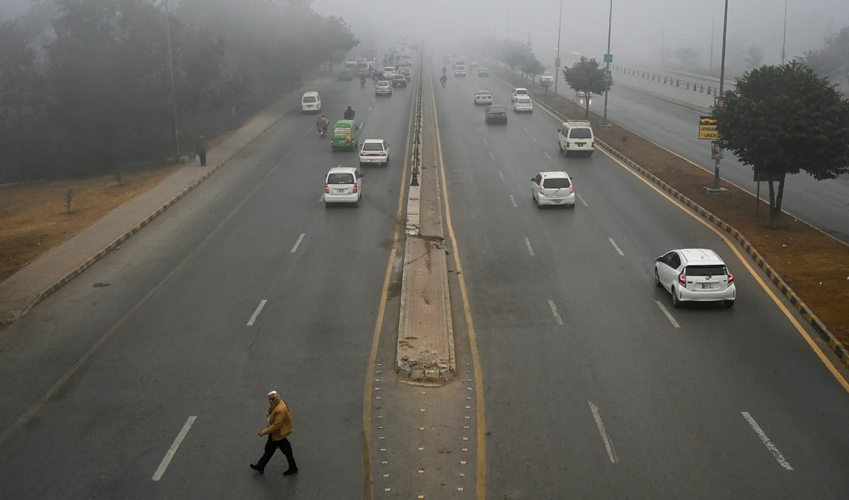 Commuters make their way along a road amid dense smog in Islamabad on January 22, 2024. (AFP/File)