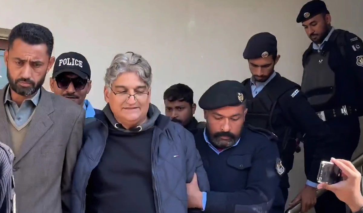In this screengrab, taken from a video posted by Pakistani journalist Farhan Khan on social media platform X, police officials escort journalist Matiullah Jan (2L) after presenting him in an anti-terrorism court in Islamabad on November 30, 2024. (Photo courtesy: Screengrab/X/@TheFarhanAKhan)