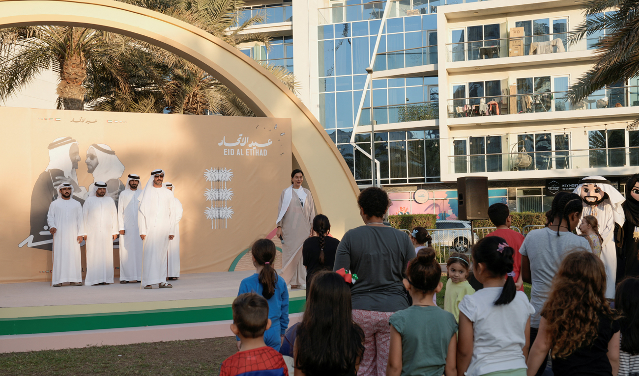 People stand together as they take part in celebrations for the UAE National Day festivities, during the National Anthem in Dubai on November 29, 2024. (REUTERS)