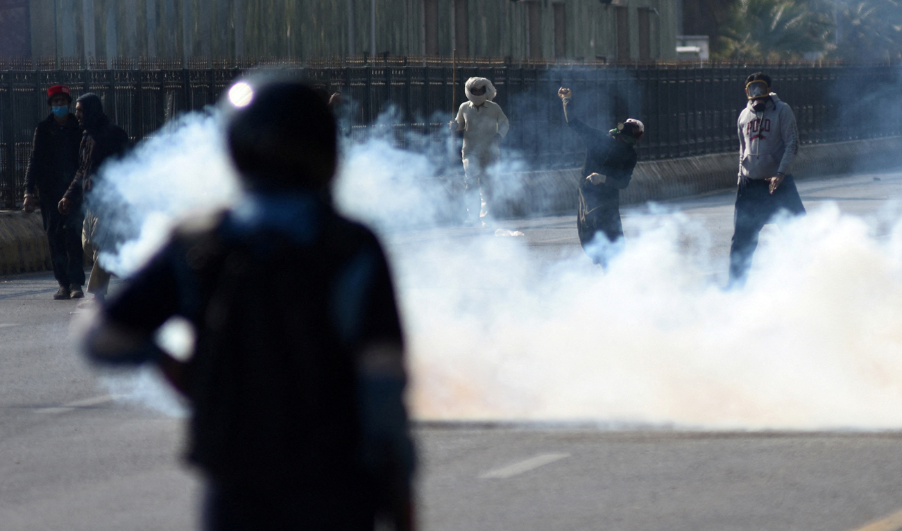 A supporter of the jailed former Pakistani Prime Minister Imran Khan’s party Pakistan Tehreek-e-Insaf (PTI) throws an object toward security force personnel during a protest rally demanding Khan’s release, in Islamabad on November 26, 2024. (REUTERS/File)