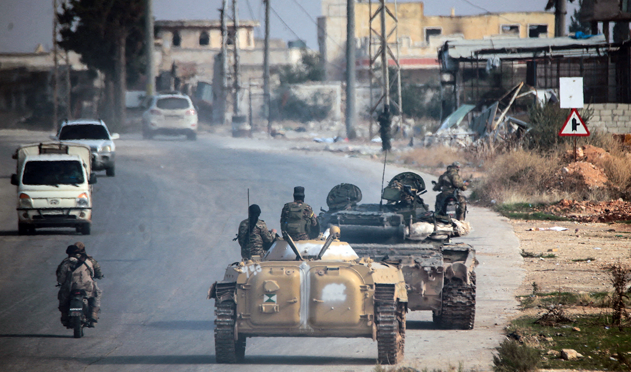 Rebels led by the Islamist militant group Hayat Tahrir Al-Sham drive along a street in the Al-Rashideen district of Aleppo province, Syria, on November 29, 2024. (Reuters)