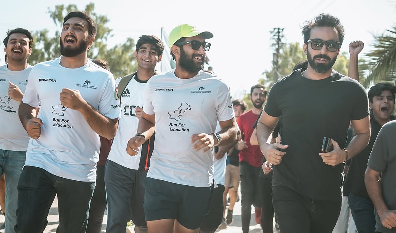 This handout photograph, posted on December 7, 2024, shows Pakistani activist and business analyst Tabarak Rehman (2R) during his marathon campaign in Karachi, to raise $1 million to educate 7,000 children in Pakistan. (Photo courtesy: Instagram/tabarakruns)