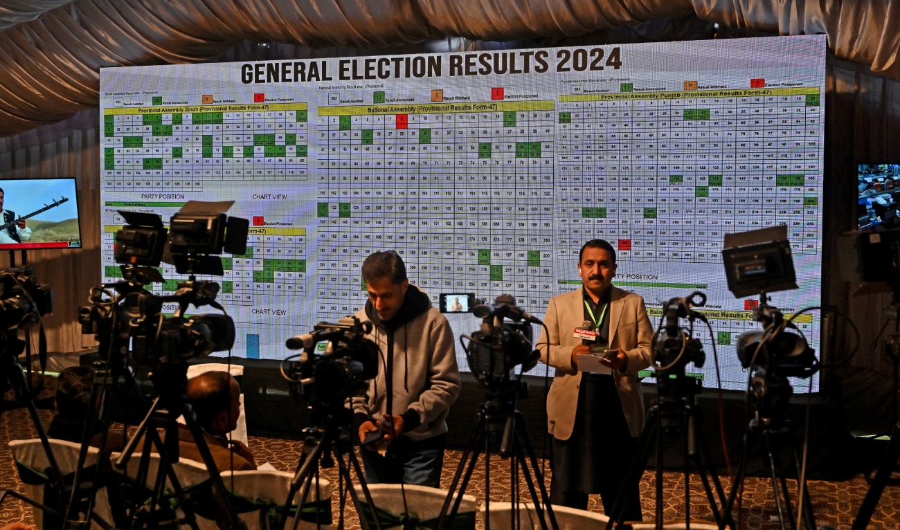 Journalists stand in front of a screen showing live results in the Election Commission office in Islamabad on February 9, 2024, a day after Pakistan's national elections. (AFP/File)