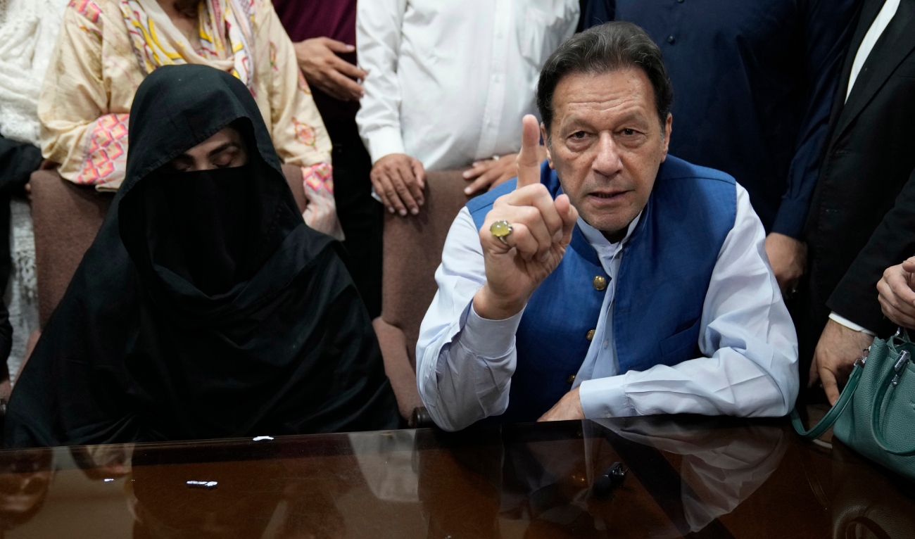 Pakistan's former Prime Minister, Imran Khan (R) along with his wife Bushra Bibi (L) looks on as he signs surety bonds for bail in various cases, at a registrar office in the High court, in Lahore on July 17, 2023. (AP/File)