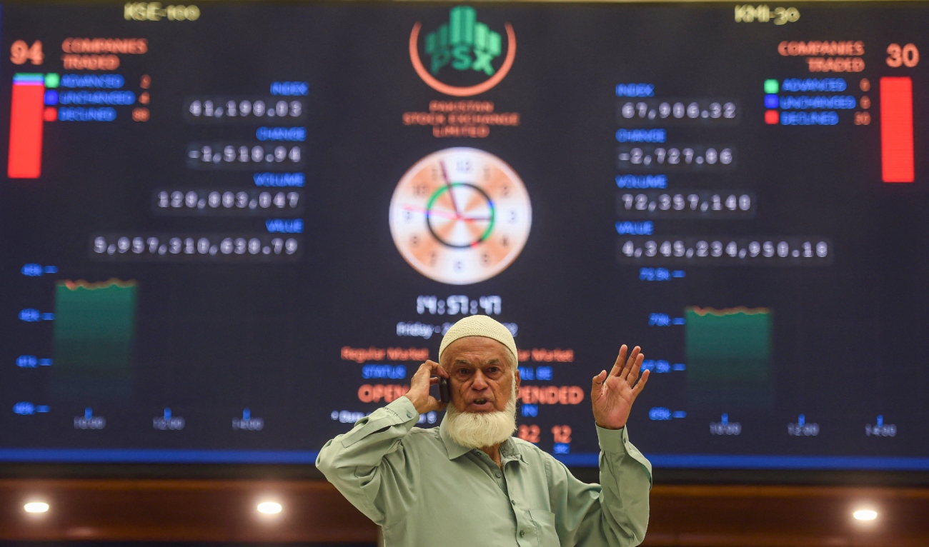 A stockbroker speaks on a phone while monitoring the share prices during a trading session at the Pakistan Stock Exchange (PSX) in Karachi on June 24, 2022. (AFP/File)