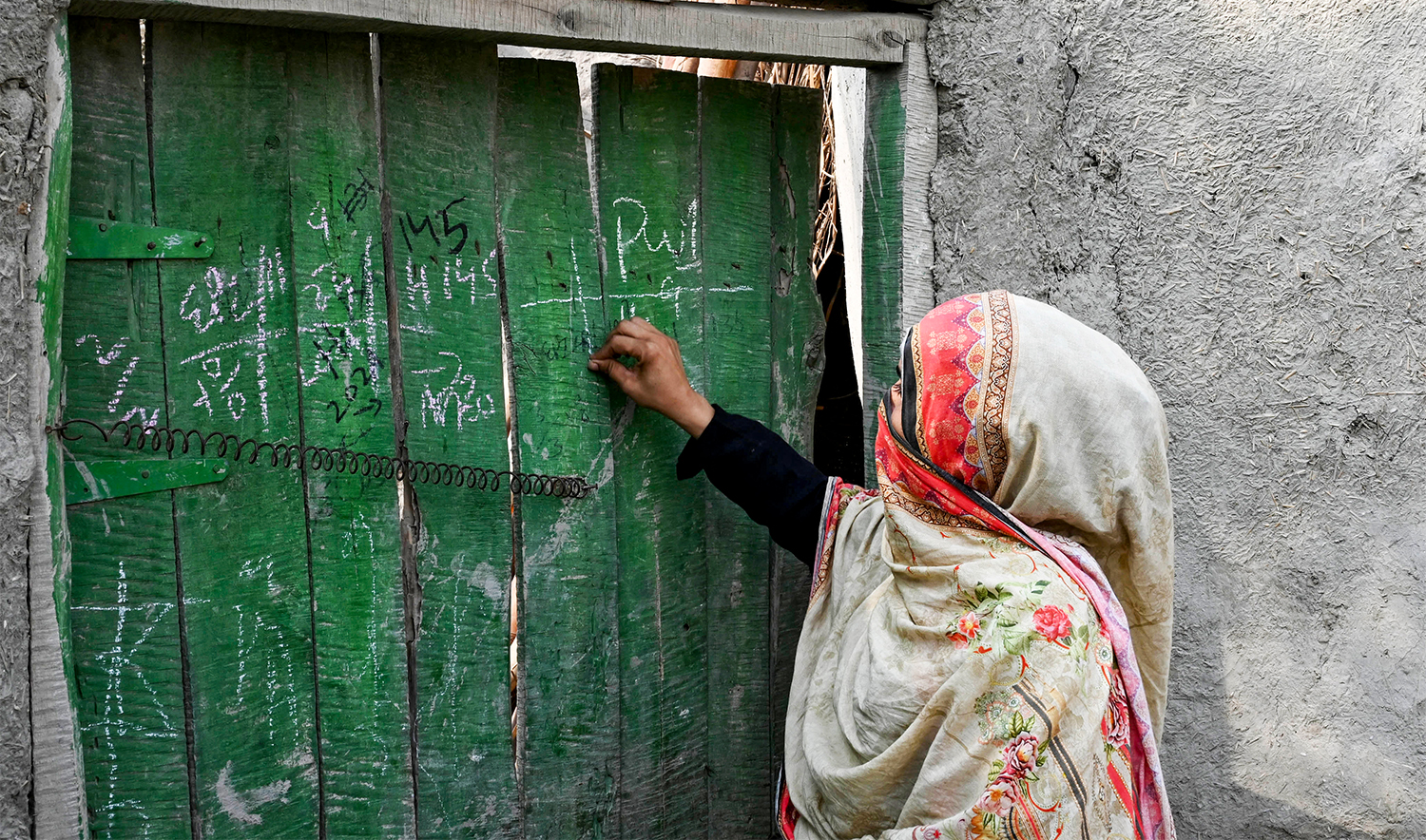 This photograph taken on October 5, 2024 shows a health worker marking a house during a door-to-door poliovirus vaccination campaign for children on the outskirts of Peshawar. (AFP/File)
