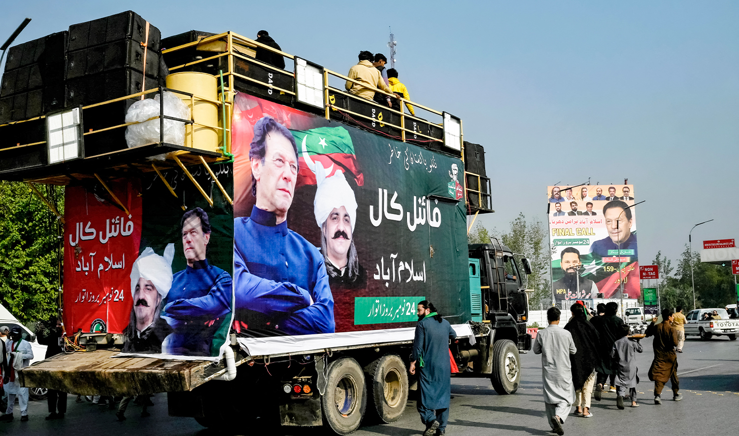 Members of jailed former prime minister Imran Khan's Pakistan Tehreek-e-Insaf (PTI) party walk beside a truck with his banner, as they head for a rally demanding his release, in Peshawar on November 24, 2024. (AFP/File)