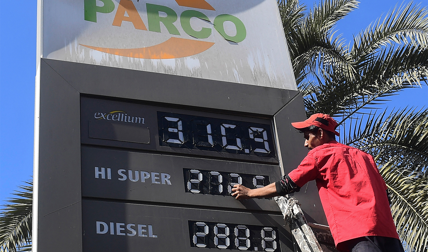 An employee of a petrol station updates the latest fuel prices on a board in Karachi on February 16, 2023. (AFP/File)