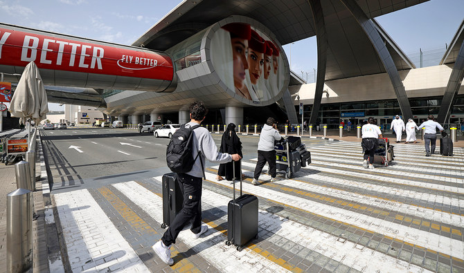 Travellers arrive with their luggage outside Dubai International Airport on February 21, 2022. (AFP/File)