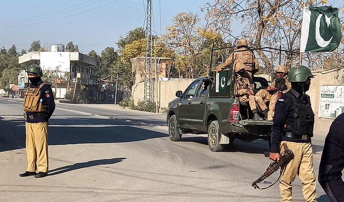 An Army vehicle patrols, past police officers stand guard along a road, near cantonment area in Bannu, Pakistan December 21, 2022. (REUTERS/File)