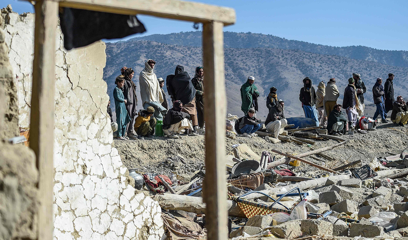 Residents gather near a damaged house two days after air strikes by Pakistan in the Barmal district of eastern Paktika province on December 26, 2024. (AFP)