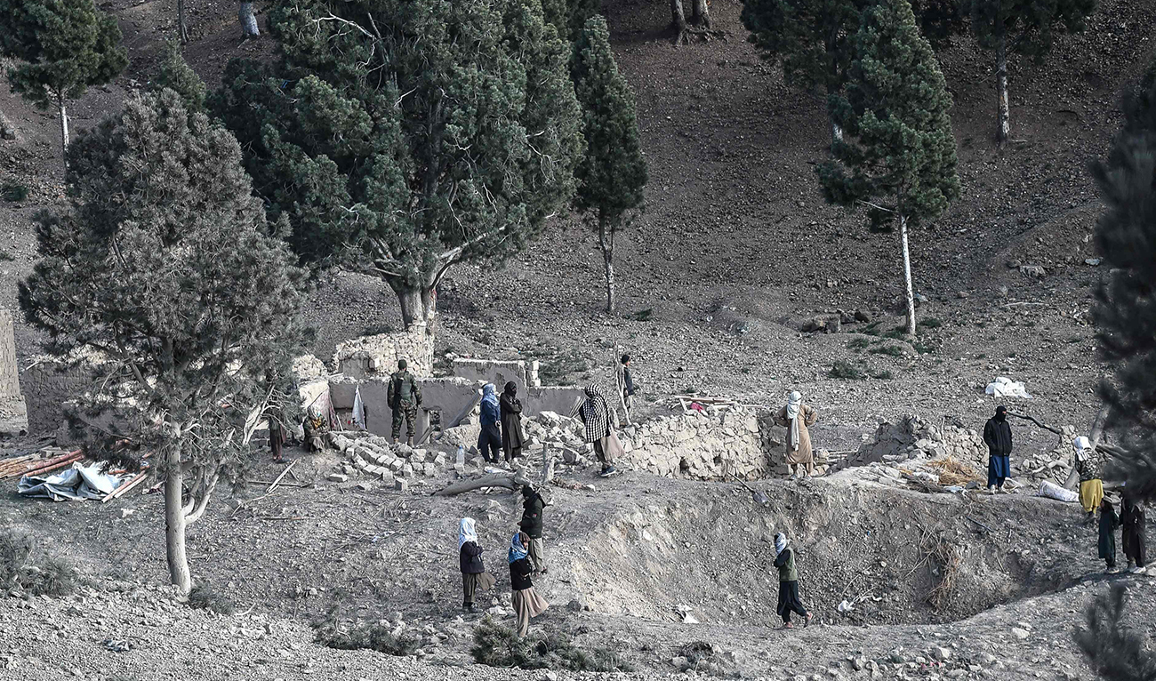 Residents gather near a damaged house two days after air strikes by Pakistan in the Barmal district of eastern Paktika province on December 26, 2024. (AFP)
