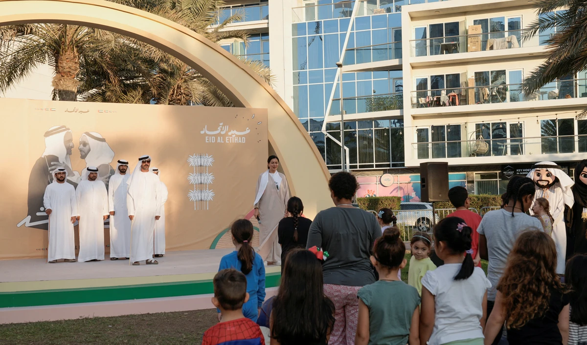 People stand together as they take part in celebrations for the UAE National Day festivities, during the National Anthem in Dubai on November 29, 2024. (REUTERS)