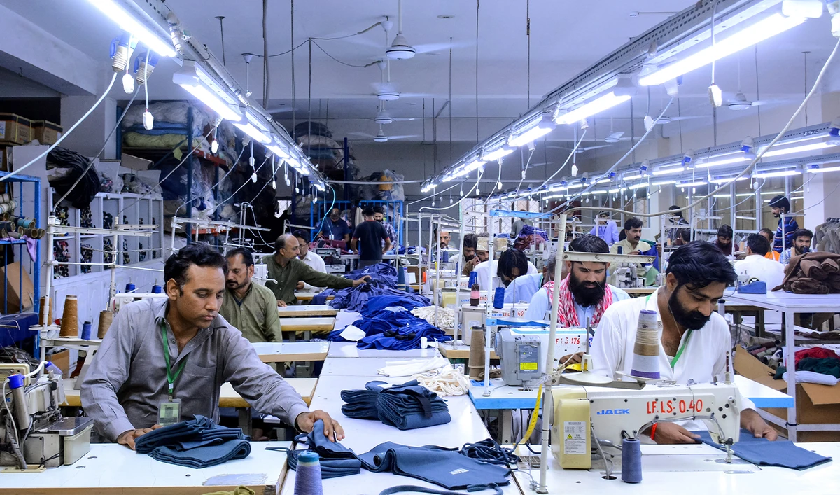 Tailors work at a garment factory in Faisalabad on June 13, 2024. (AFP/File)