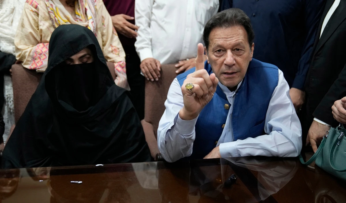 Pakistan's former Prime Minister, Imran Khan (R) along with his wife Bushra Bibi (L) looks on as he signs surety bonds for bail in various cases, at a registrar office in the High court, in Lahore on July 17, 2023. (AP/File)