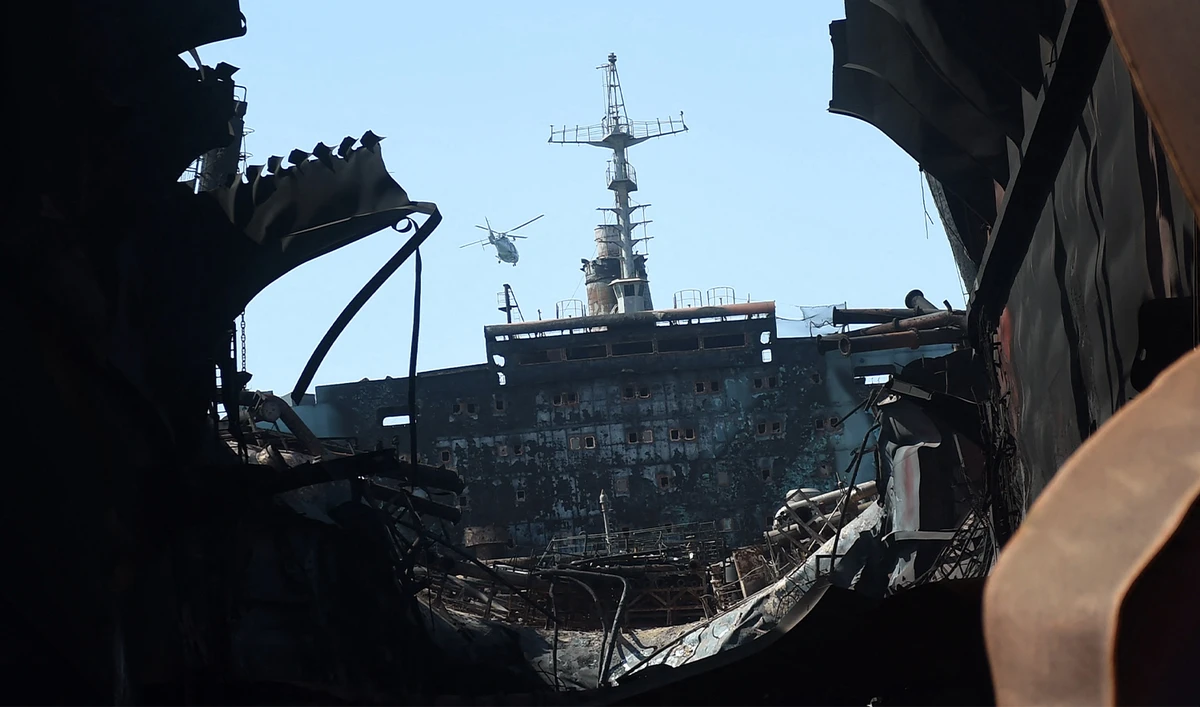 In this photograph taken on November 8, 2016, a helicopter flies over the wreckage of a burnt out ship which was hit by a gas cylinder explosion on November 1, at the Gadani Shipbreaking Yard, some 50 kilometres west of Karachi. (AFP/File)