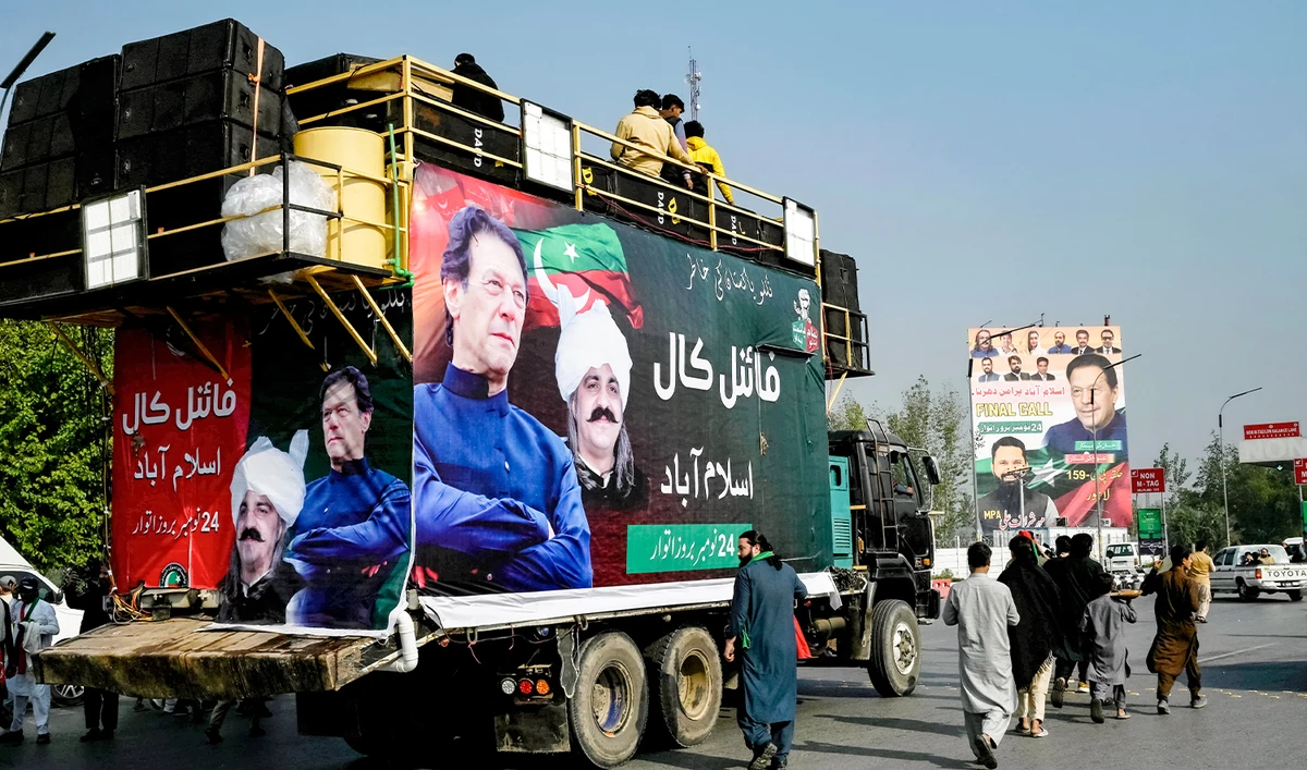 Members of jailed former prime minister Imran Khan's Pakistan Tehreek-e-Insaf (PTI) party walk beside a truck with his banner, as they head for a rally demanding his release, in Peshawar on November 24, 2024. (AFP/File)