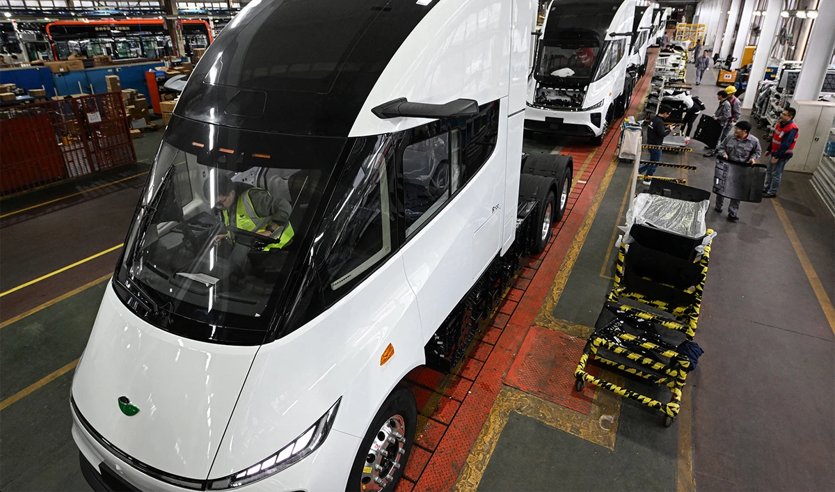 This photo taken in November 18, 2024 shows employees of Chinese electric truck startup Windrose working on an electic truck assembly line at a factory in Suzhou, in eastern China's Jiangsu province. (AFP/File)