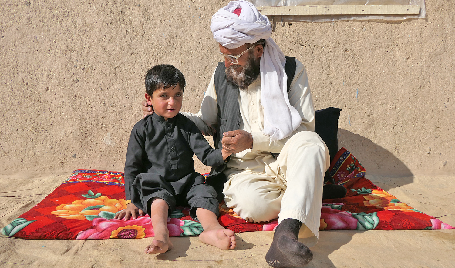 Haji Abdullah Khan (right) chats with his polio-affected son Muhammad Hamza in Pakistan's southwestern Pishin district on December 27, 2024. (AN photo)