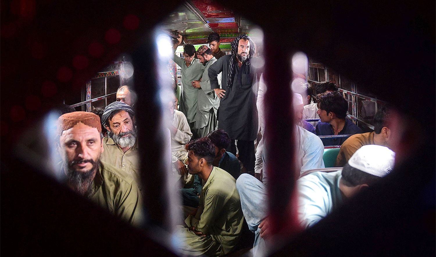 Detained Afghan refugees sit in a bus during a late night search operation by the police personnel to identify allegedly illegal immigrants, in the outskirts of Karachi on November 11, 2023. (AFP)