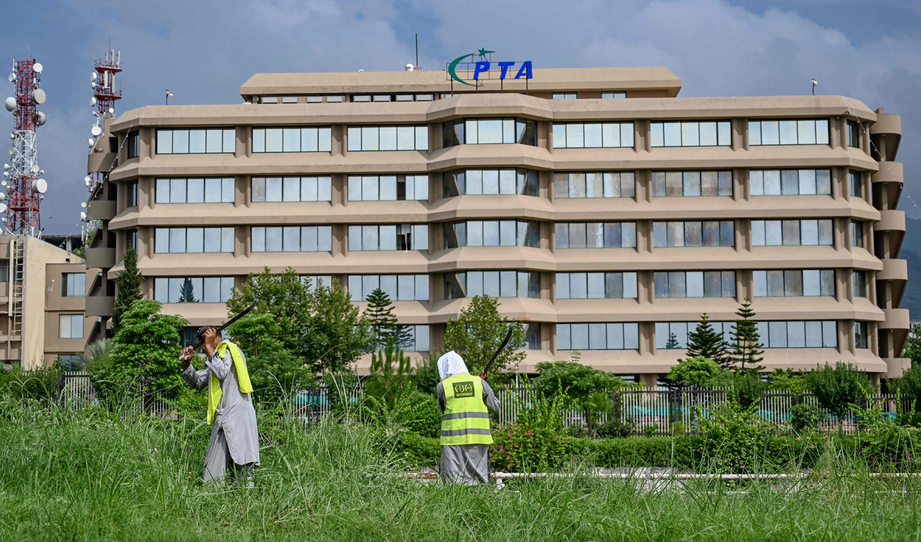 Gardeners work near the Pakistan Telecommunication Authority (PTA) headquarters building in Islamabad on August 16, 2024. (AFP/File)