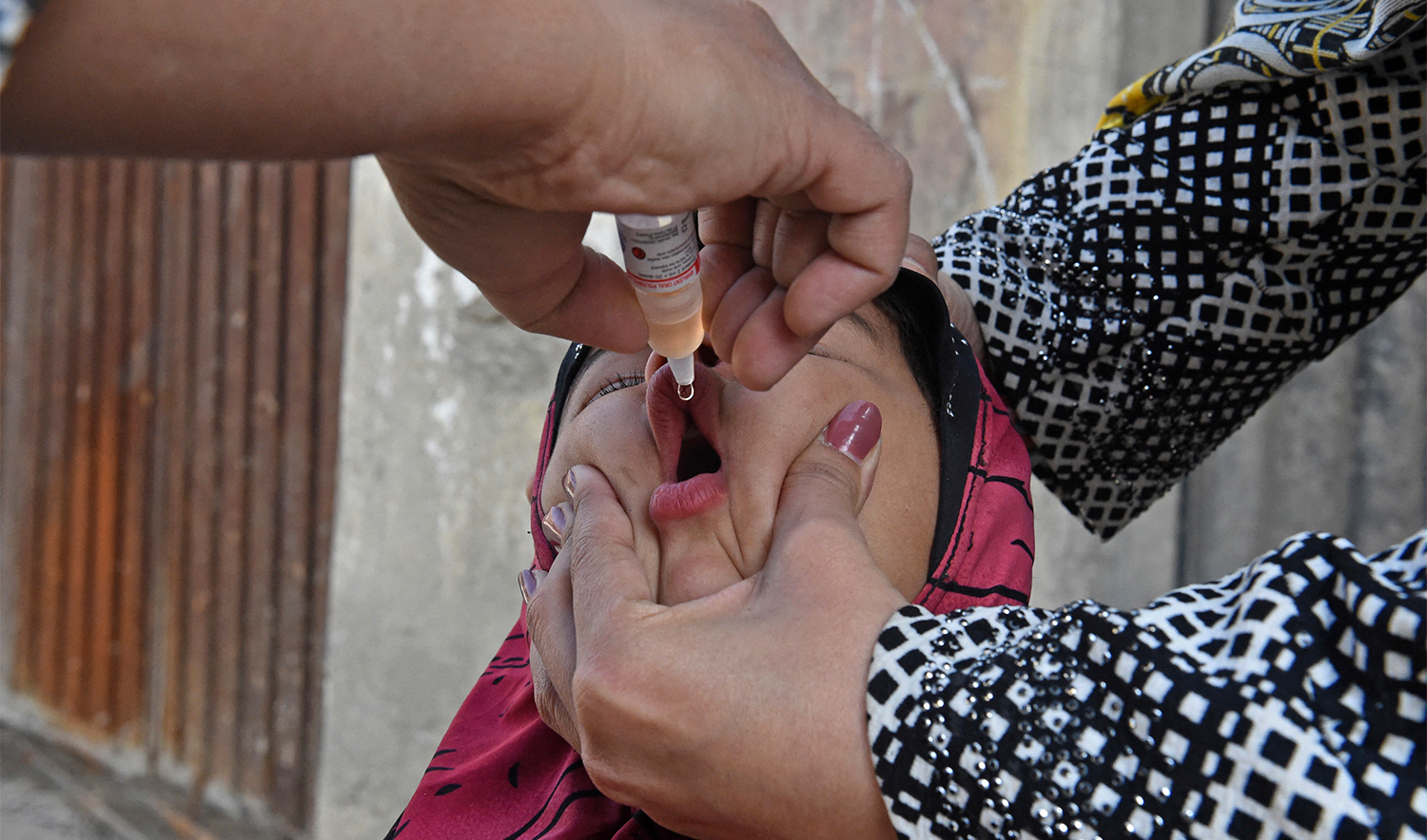 A health worker administers polio vaccine drops to a child during a polio vaccination door-to-door campaign in Quetta on December 2, 2020. (AFP/File)