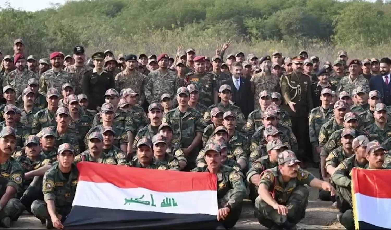 Soldiers hold Iraqi national flag at a ceremony marking the 104th anniversary of Iraq's national army in Pabbi, Pakistan, on January 8, 2024. (Pakistan Army)