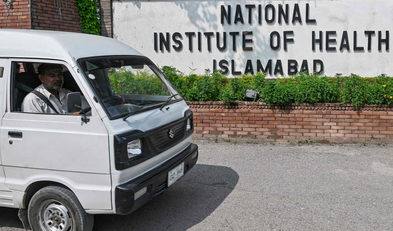A man riding a vehicle moves past the building of National Institute of Health (NIH), a Pakistani research institute mainly responsible for biomedical and health related research, in Islamabad on August 16, 2024. (AFP/File)