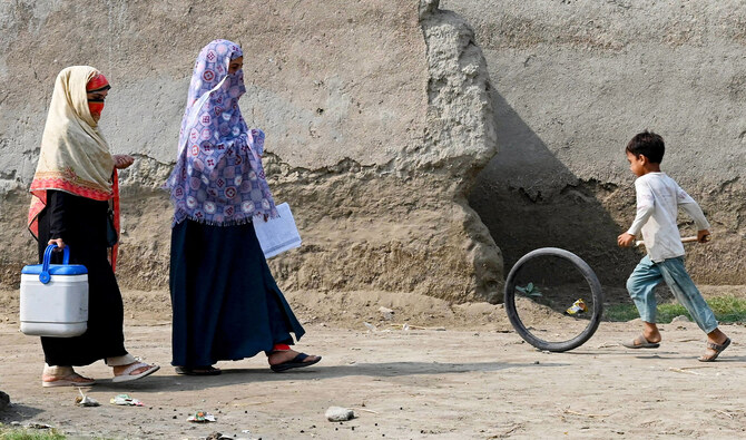 This photograph taken on October 5, 2024 shows health workers walking during a door-to-door poliovirus vaccination campaign for children on the outskirts of Peshawar. (AFP/File)