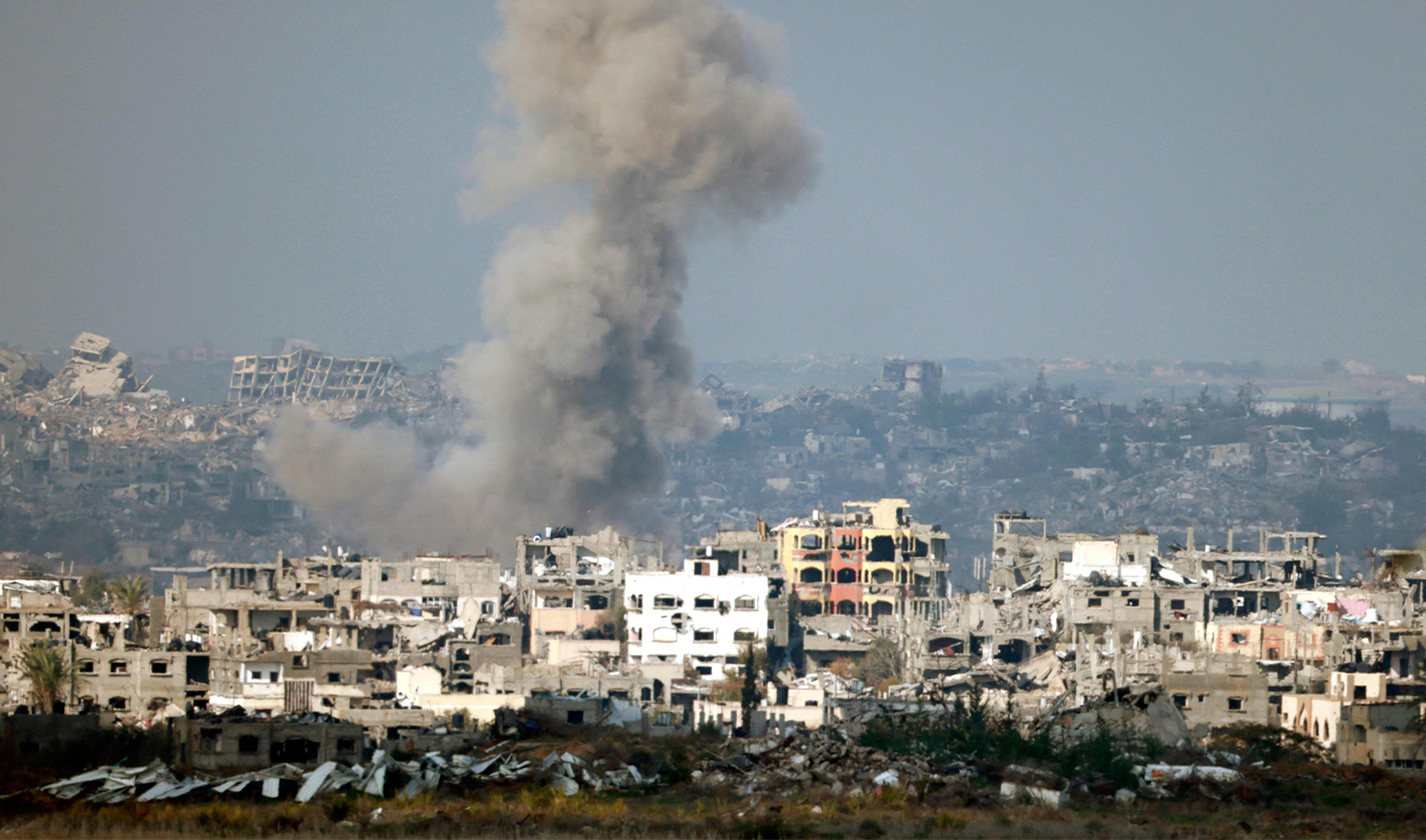This picture taken from the Israeli side of the border with the Gaza Strip shows smoke plumes rising from explosions above destroyed buildings in the northern Gaza Strip on January 16, 2025. (AFP)