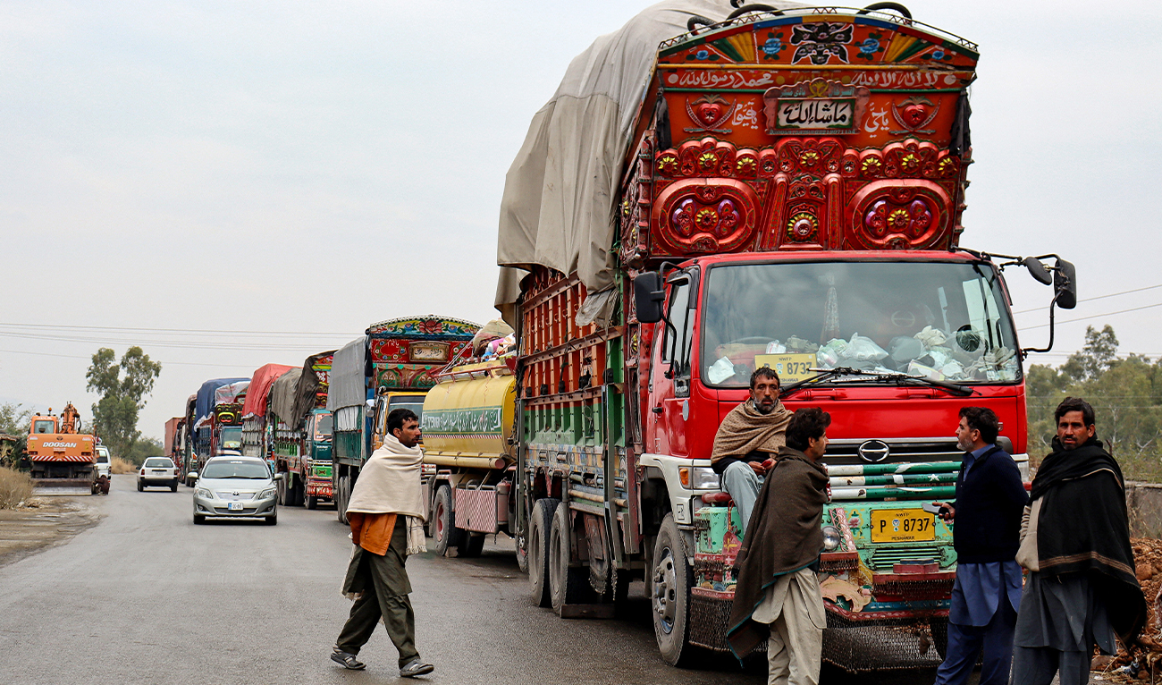 Truck drivers gather beside aid supply trucks, parked along a roadside in Hangu on January 4, 2025, after gunmen ambushed a Pakistan aid convoy. (AFP/File)
