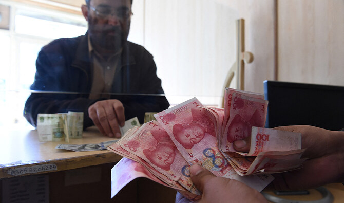 A Pakistani currency dealer counts Chinese currency for his customer at his shop in Quetta on January 3, 2018. (AFP/File)